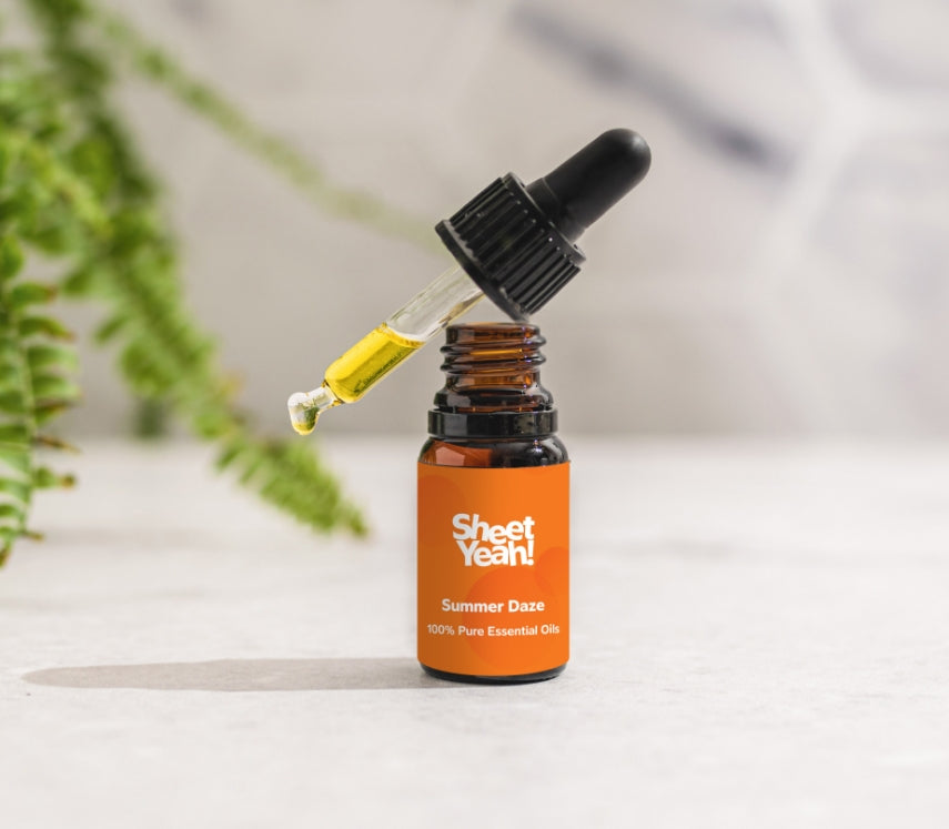 Bottle of Summer Daze Essential Oil showing the dropper on a white background with a fern to one side