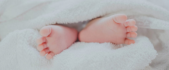 Babies feet in a soft white towel, sensitive skin and safe for babies