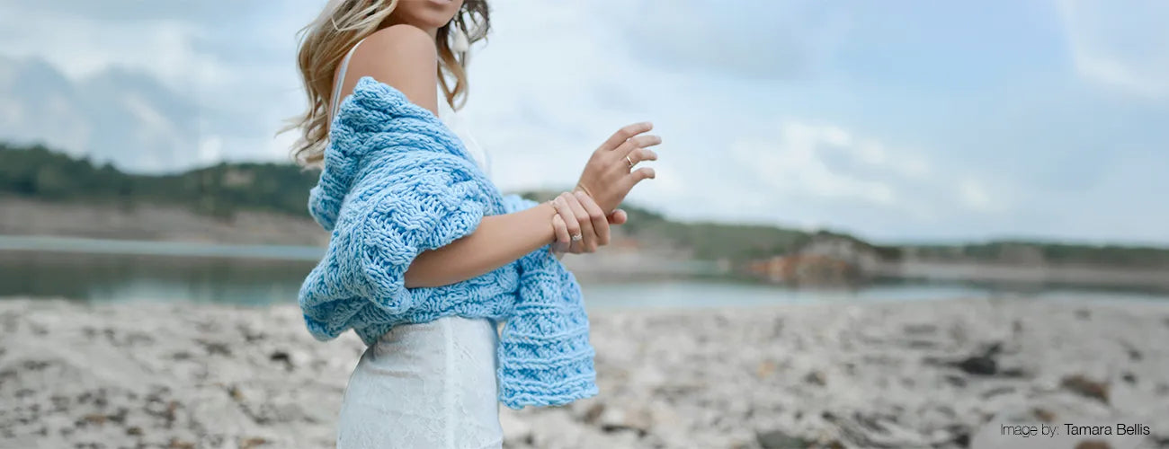 Women standing on a beach wearing a wool sweater jumper