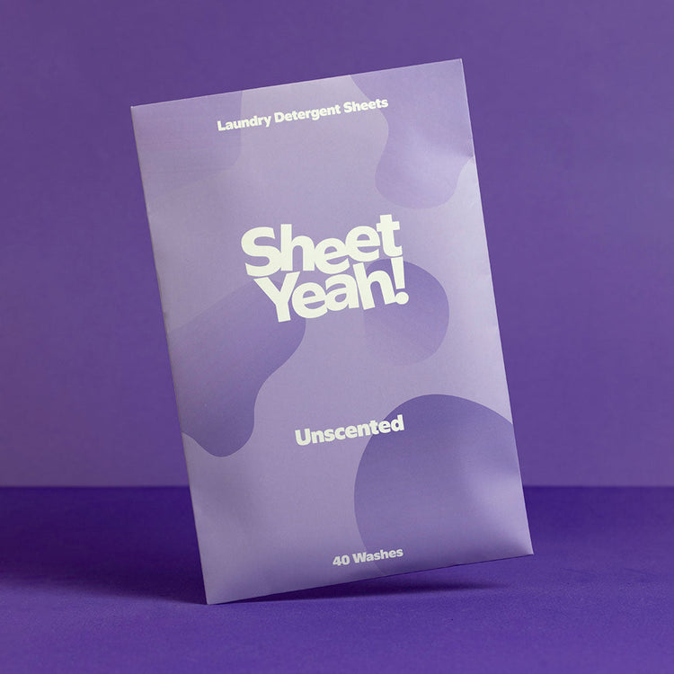 One pack of the unscented Sheet Yeah! Laundry Detergent Sheets standing in front of a purple background